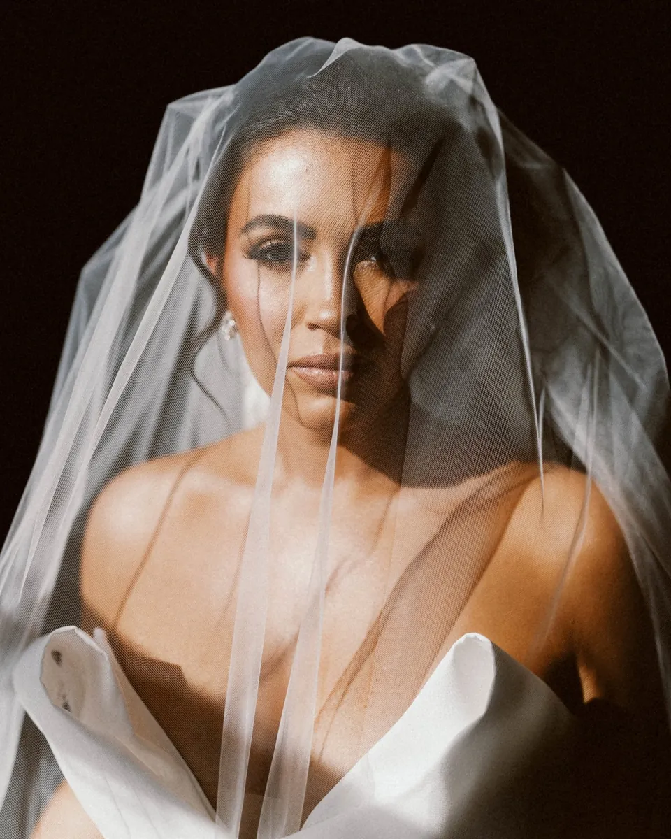 Celeste gazing through her sheer veil in dramatic light on her Philadelphia wedding day