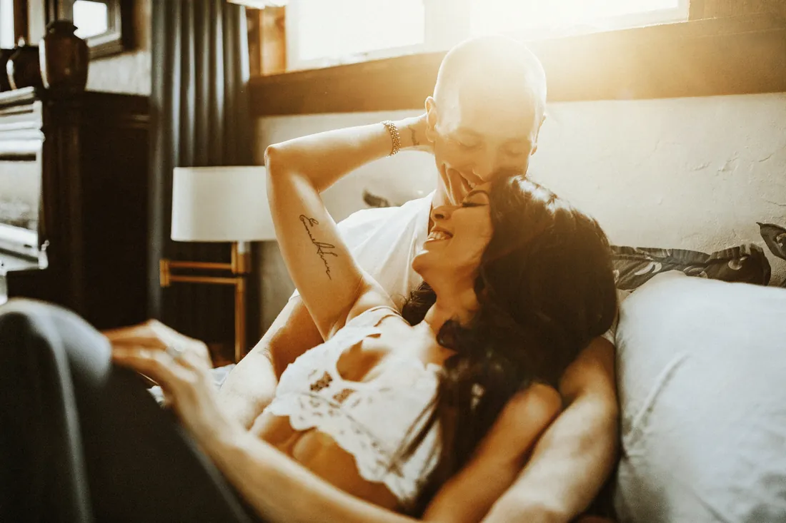 Engaged couple relaxing together in soft window light at home