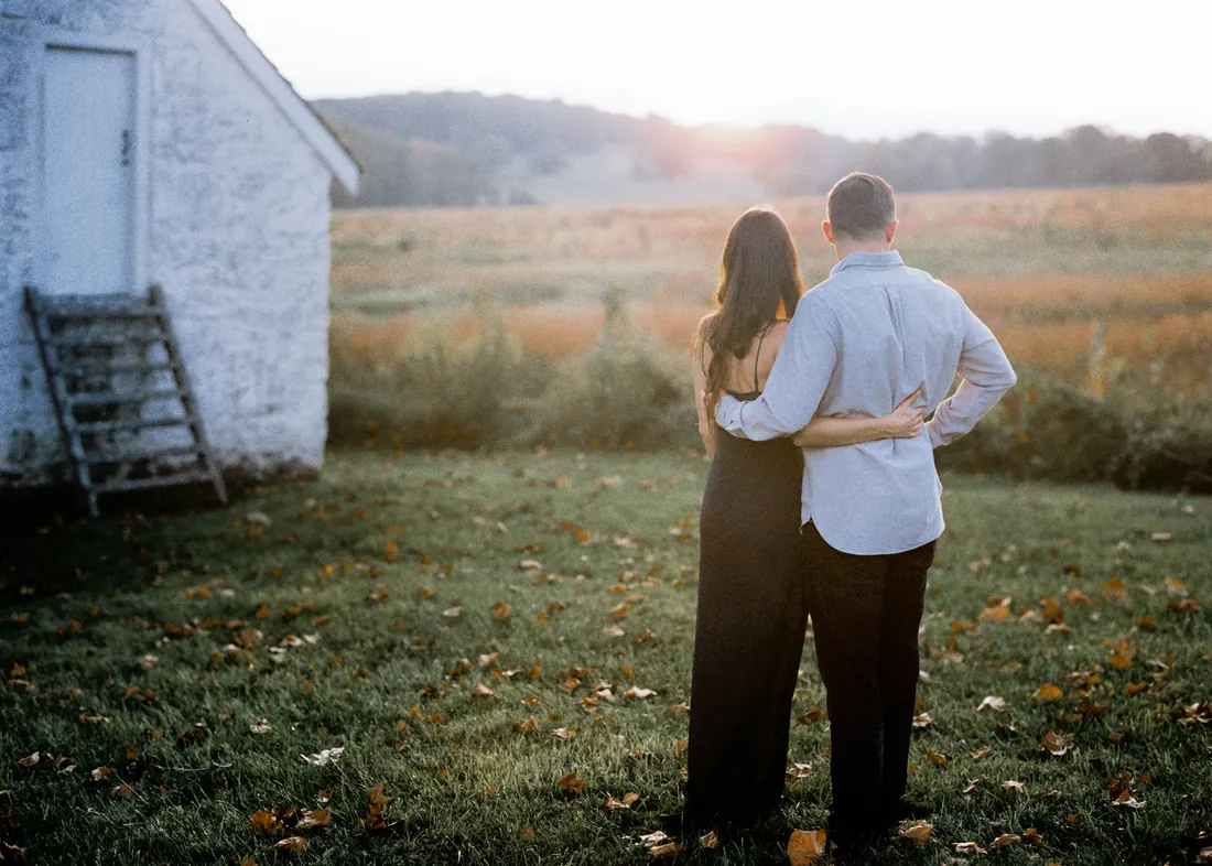 Film photograph of an engaged couple watching the sunset over a field