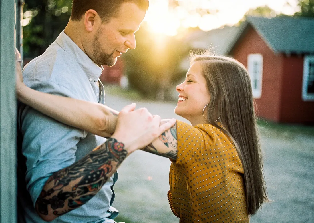 Film photograph of an engaged couple laughing together at sunset