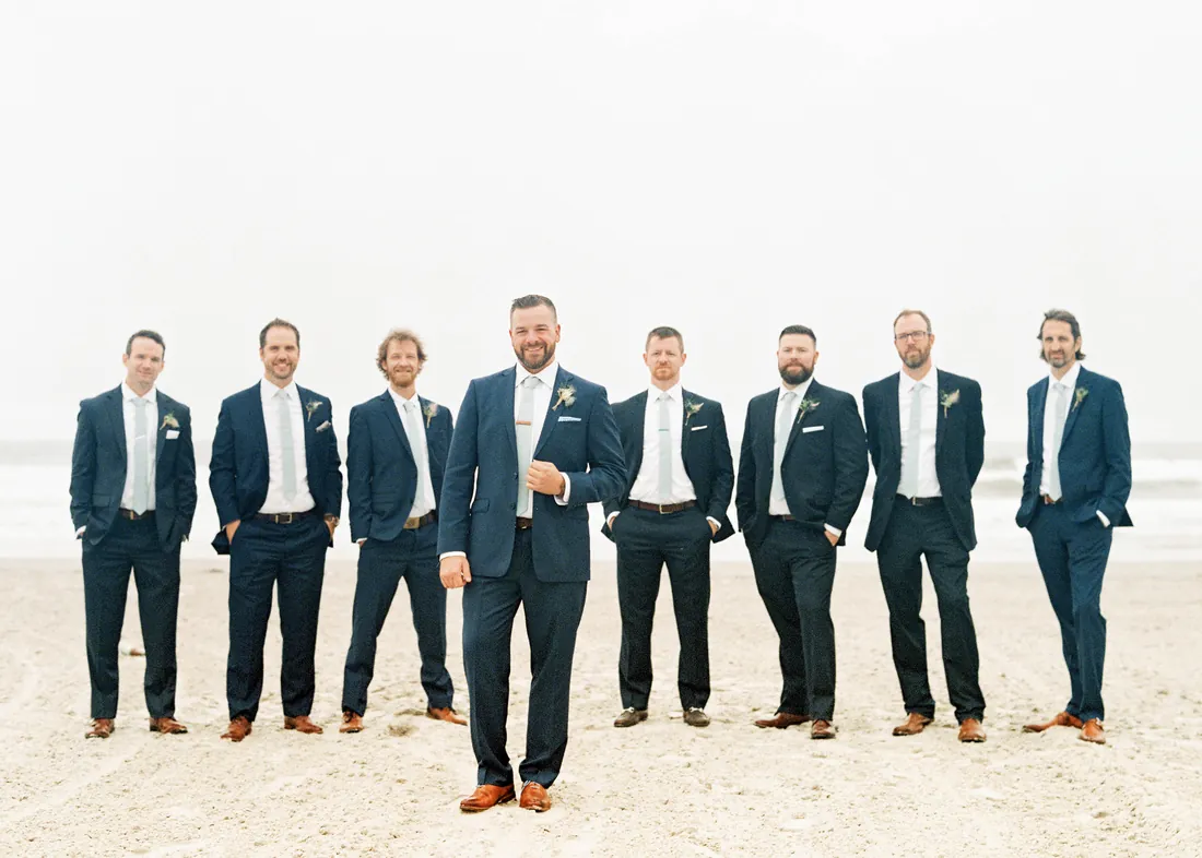 Film photograph of a groom and his groomsmen on the beach