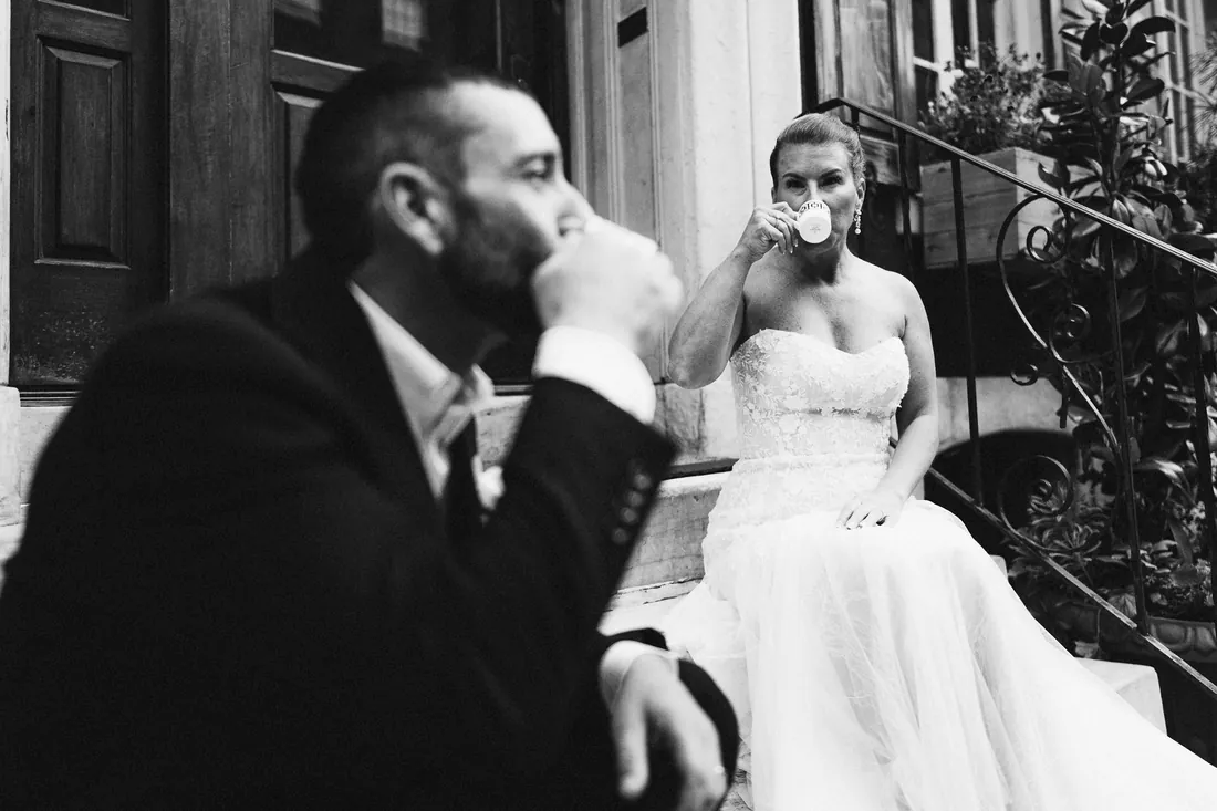 Black and white photo of a bride and groom sharing a quiet drink