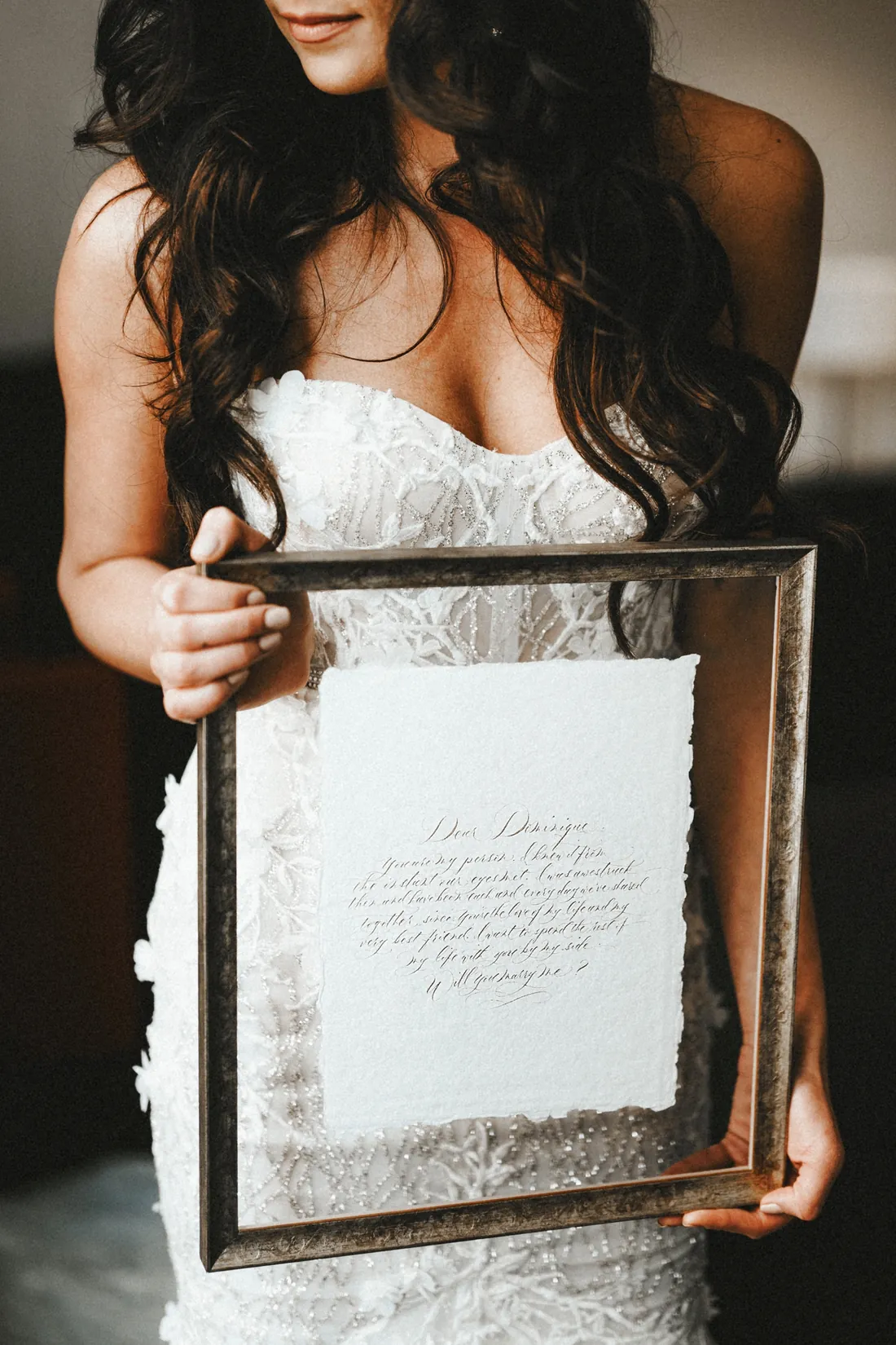 Bride holding a framed handwritten letter