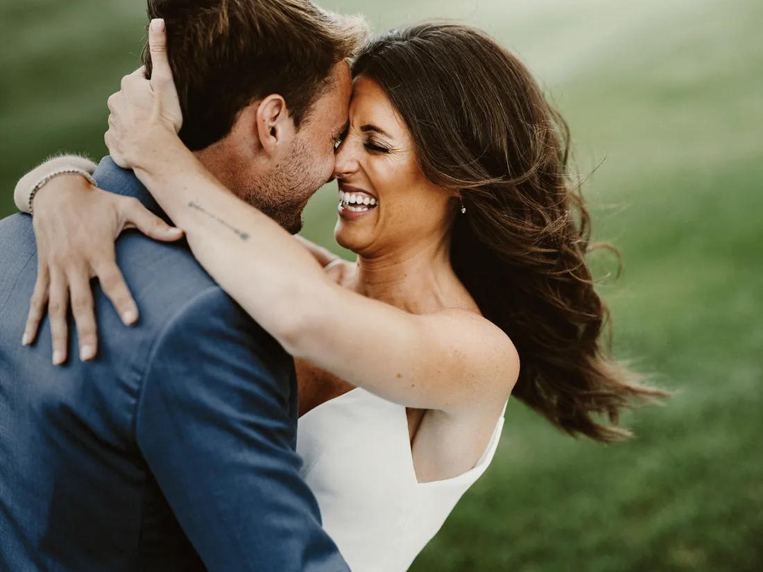 Laughing bride hugging her groom outdoors