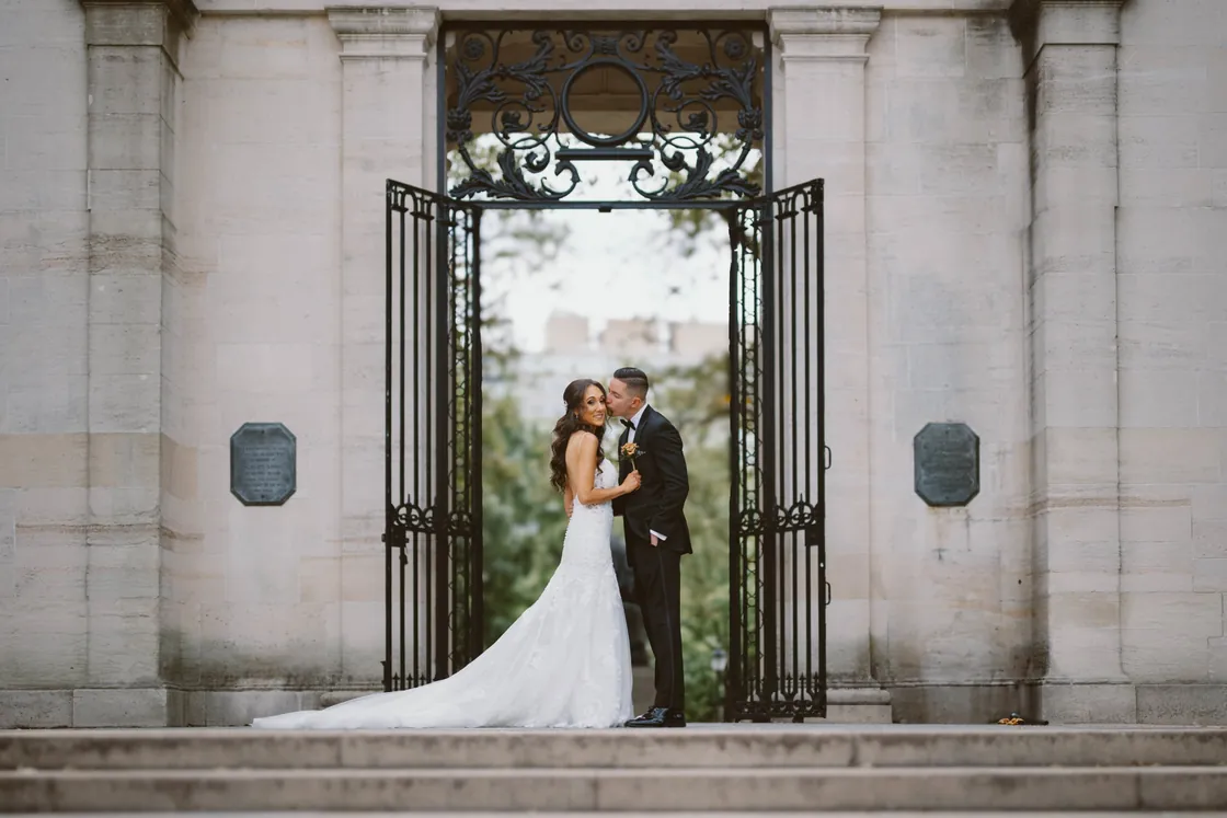Chris and Danielle sharing a kiss in front of the ornate iron gates of the Rodin Museum in Philadelphia on their Cescaphe Ballroom at the Ben wedding day