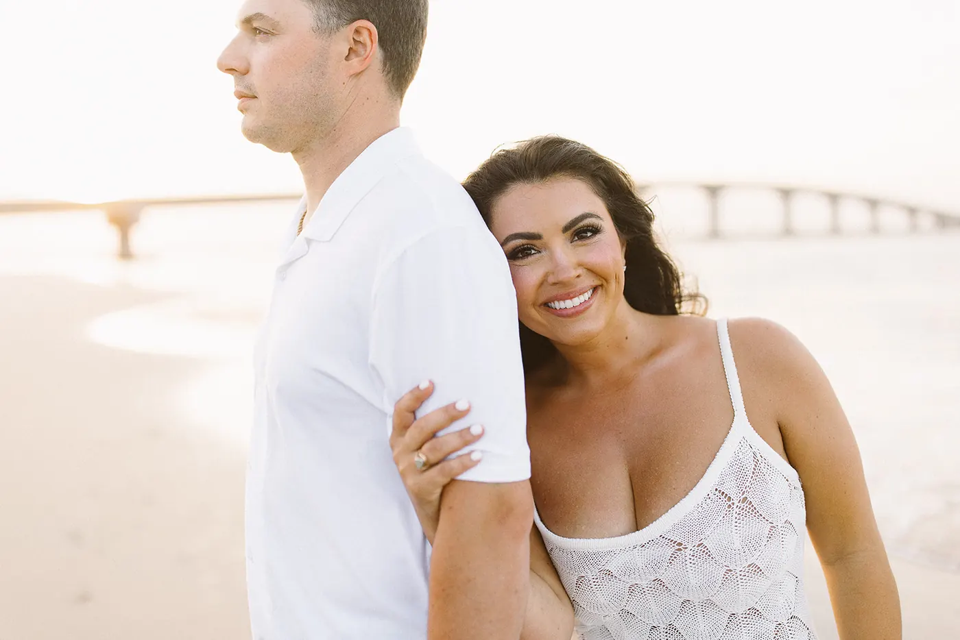Celeste smiling as she leans into Branon on the beach in Ocean City, NJ, near the Longport bridge