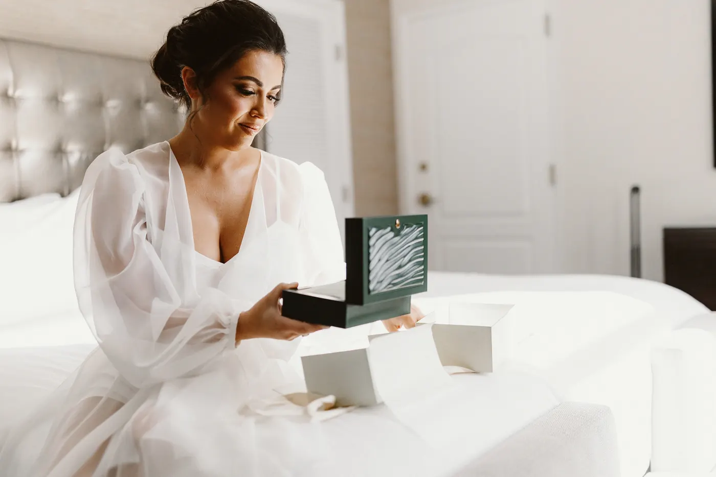 Celeste opening a gift box from Branon on the morning of the wedding