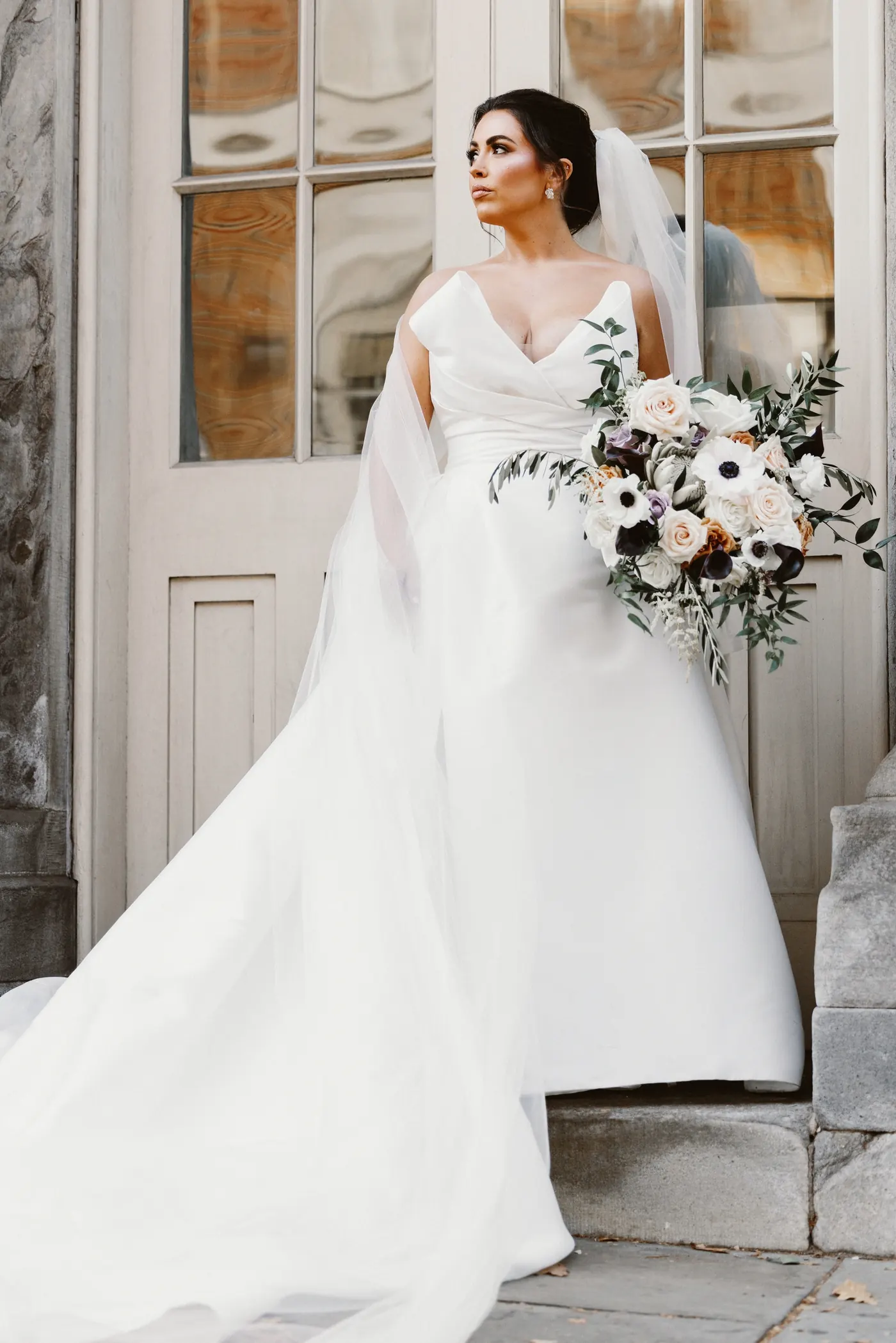 Celeste with her bouquet in front of tall wooden doors at Philadelphia City Hall