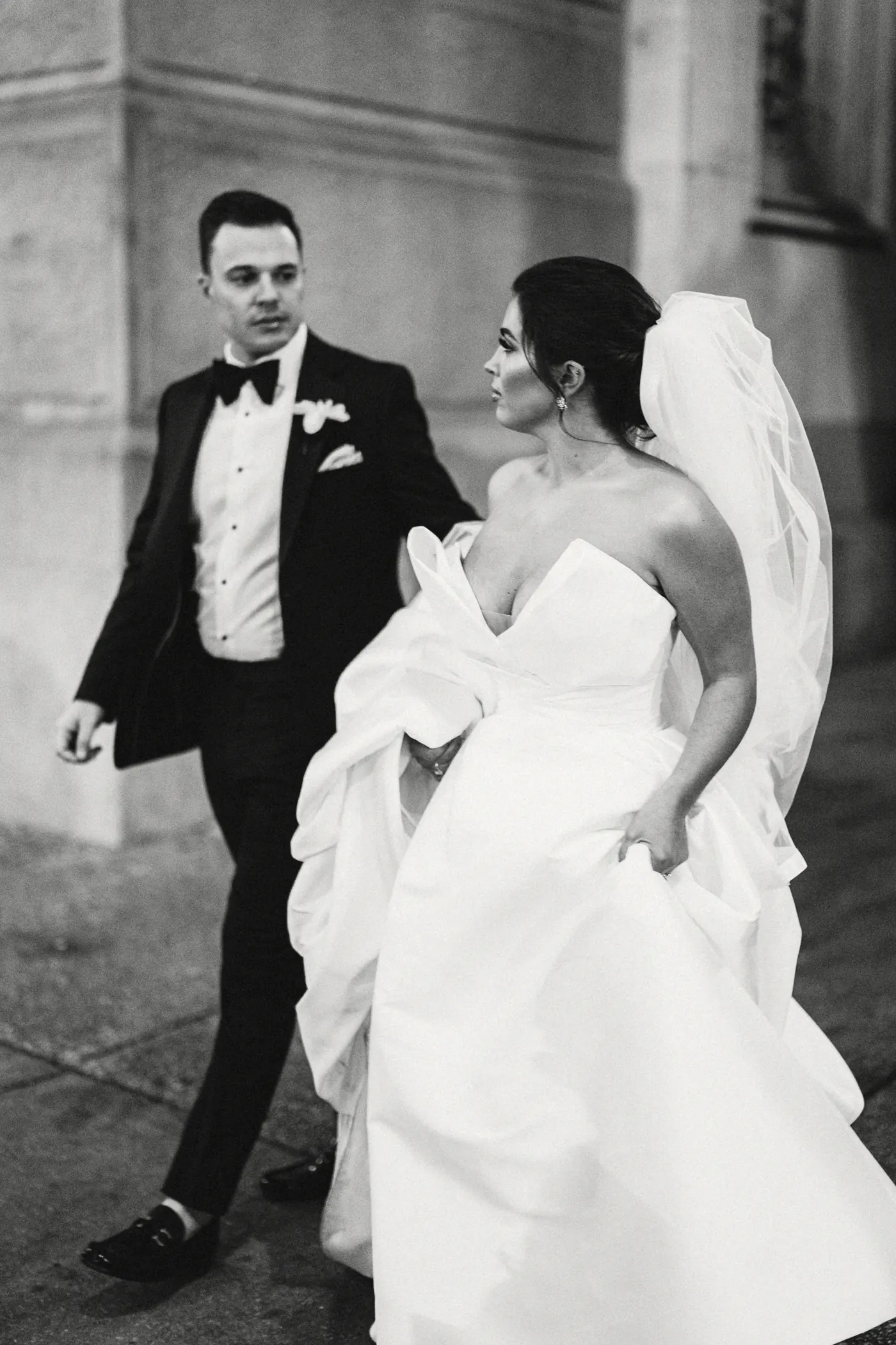 Black and white photo of Branon and Celeste walking at Philadelphia City Hall