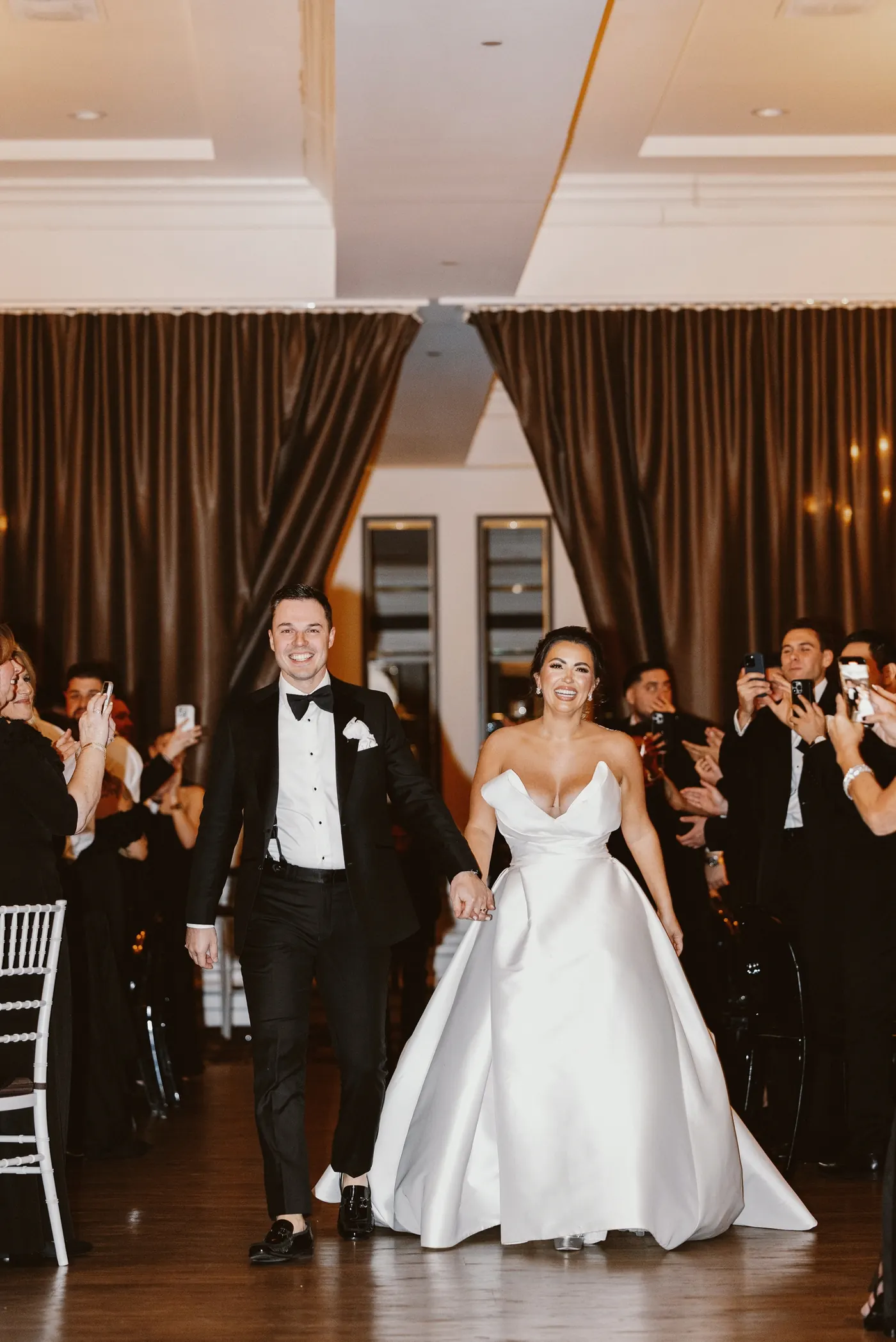 Guests cheering as Branon and Celeste enter the reception at The Vie by Cescaphe in Philadelphia