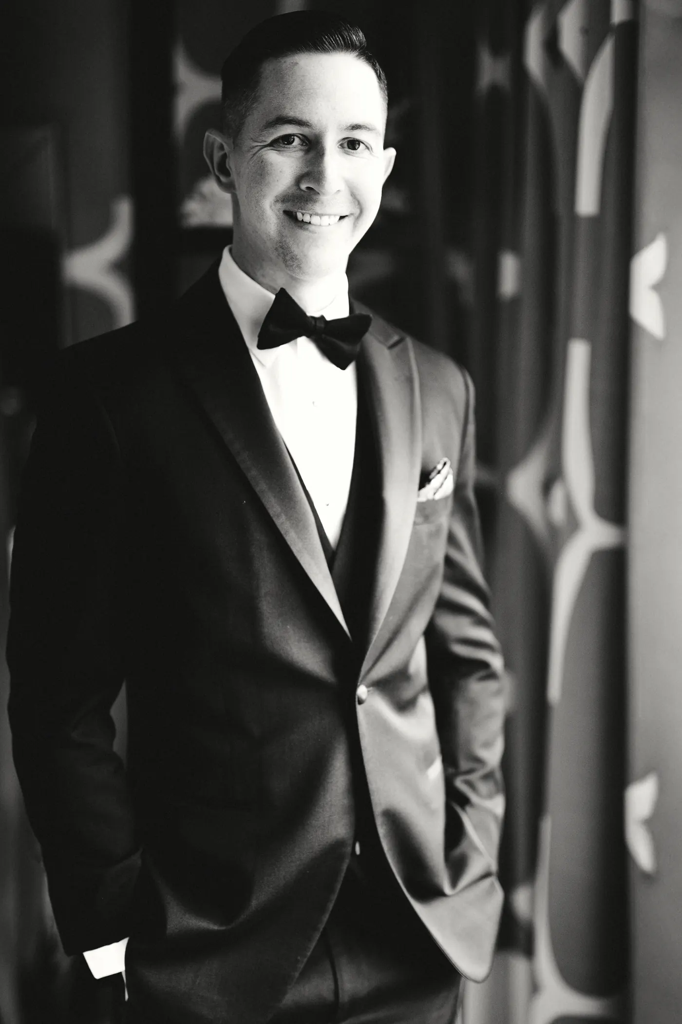 Black and white portrait of Chris smiling in his tuxedo