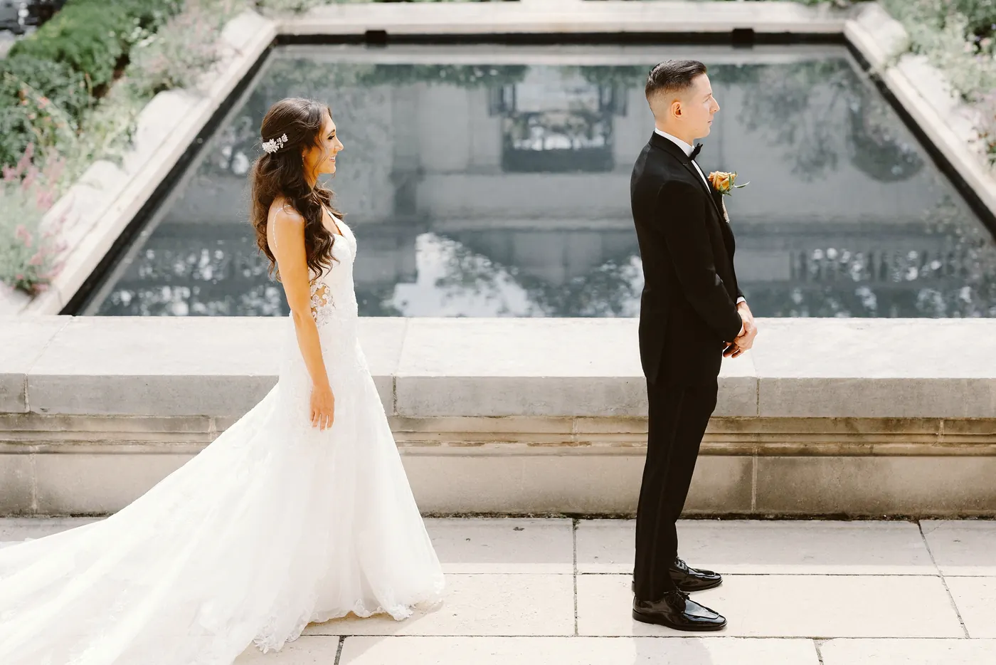 Chris and Danielle facing each other for their first look by the reflecting pool at the Rodin Museum in Philadelphia