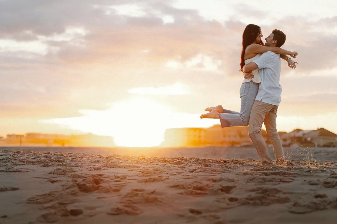 Morgan leaping into Mason's arms at sunset during their Congress Hall, Cape May engagement session