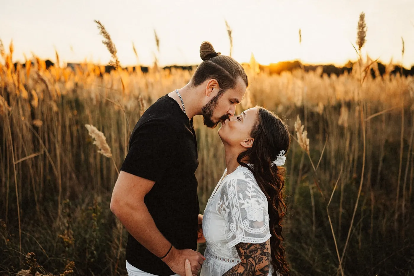 Dan and Madison leaning in for a kiss at golden hour near Barnegat Lighthouse on Long Beach Island, NJ