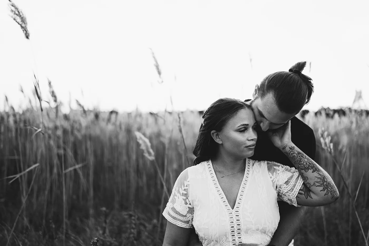 Black and white photo of Dan and Madison cheek to cheek in the dune grass near Barnegat Lighthouse on Long Beach Island, NJ