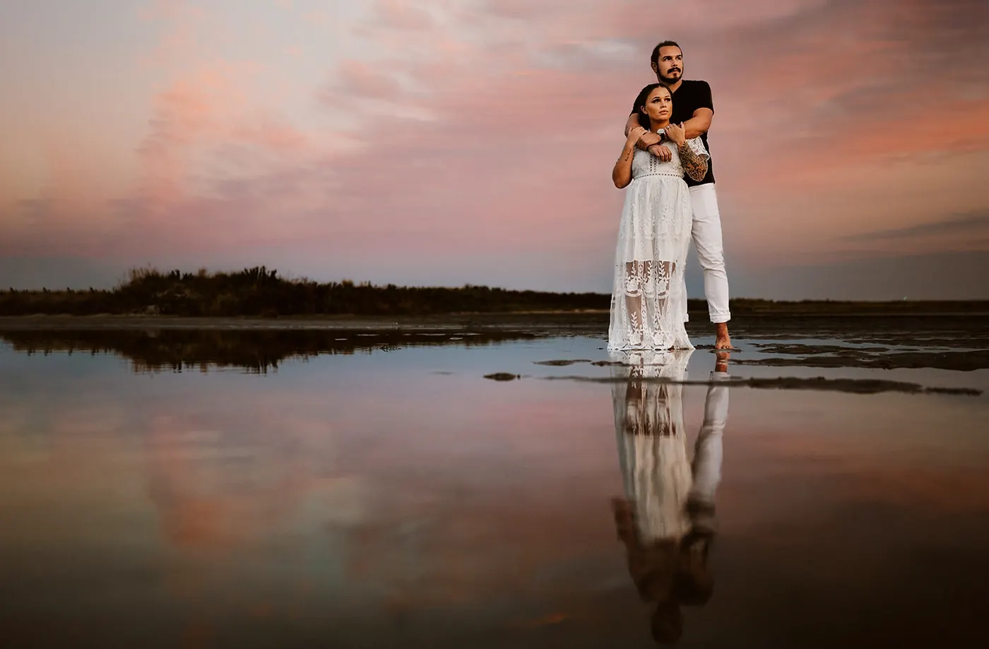 Dan and Madison mirrored in still water under a pink sunset near Barnegat Lighthouse on Long Beach Island, NJ
