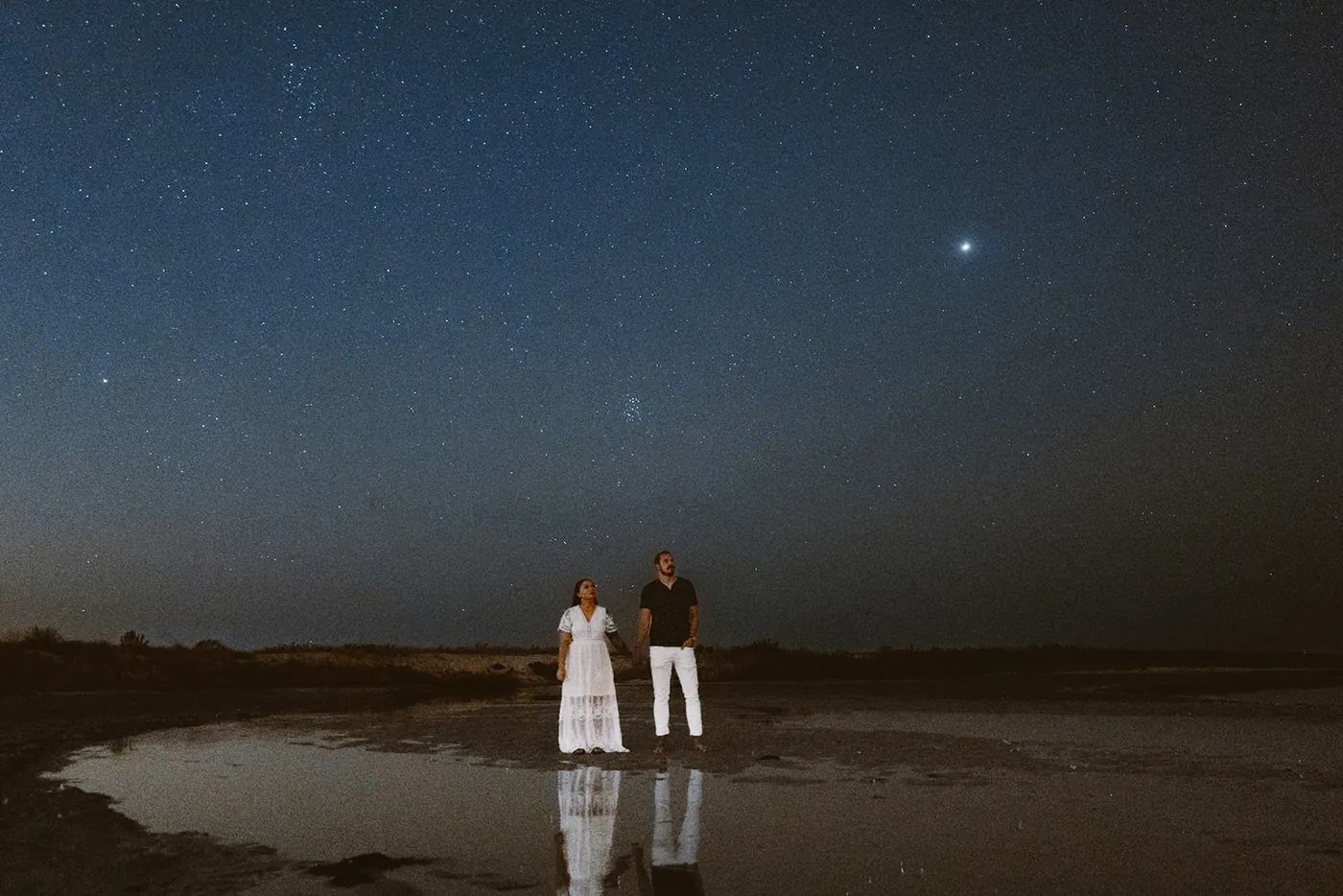 Dan and Madison standing by the water as the first stars come out near Barnegat Lighthouse on Long Beach Island, NJ
