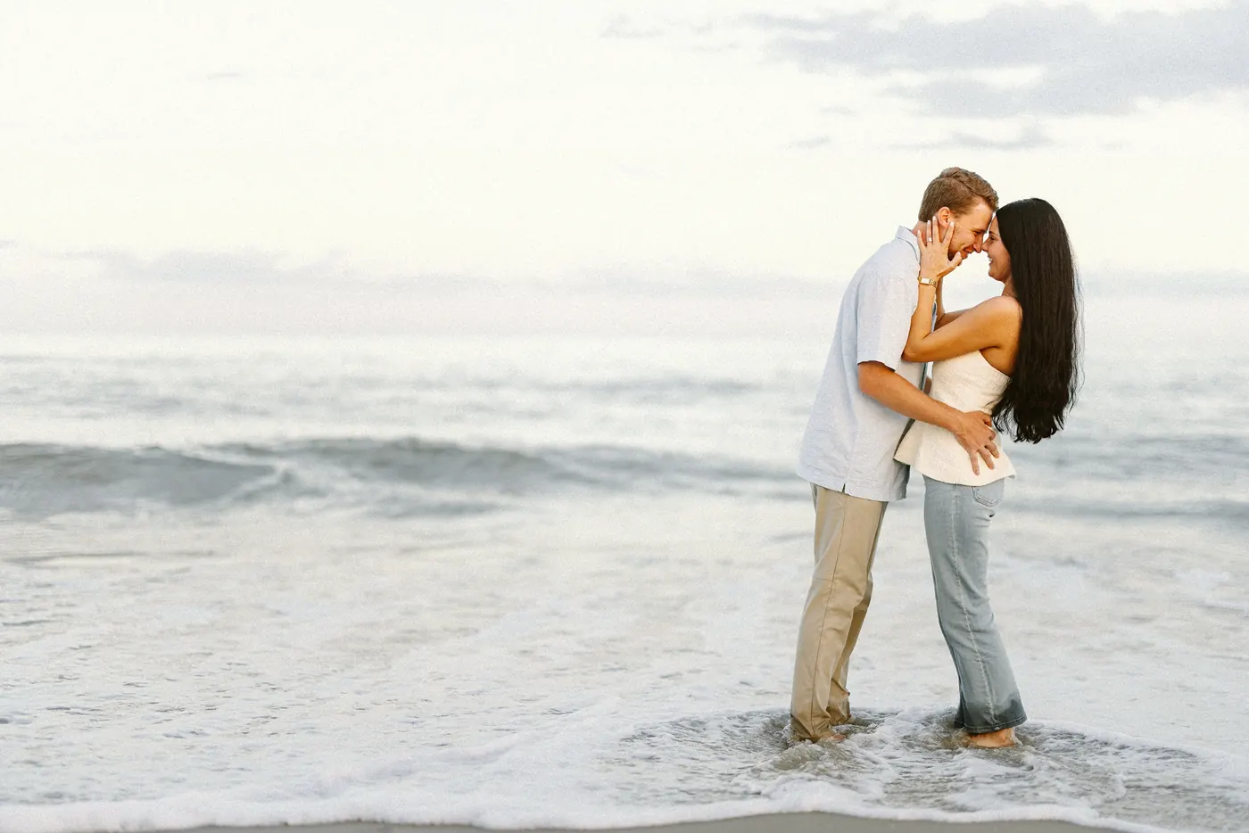 Mason and Morgan kissing in the shallow waves