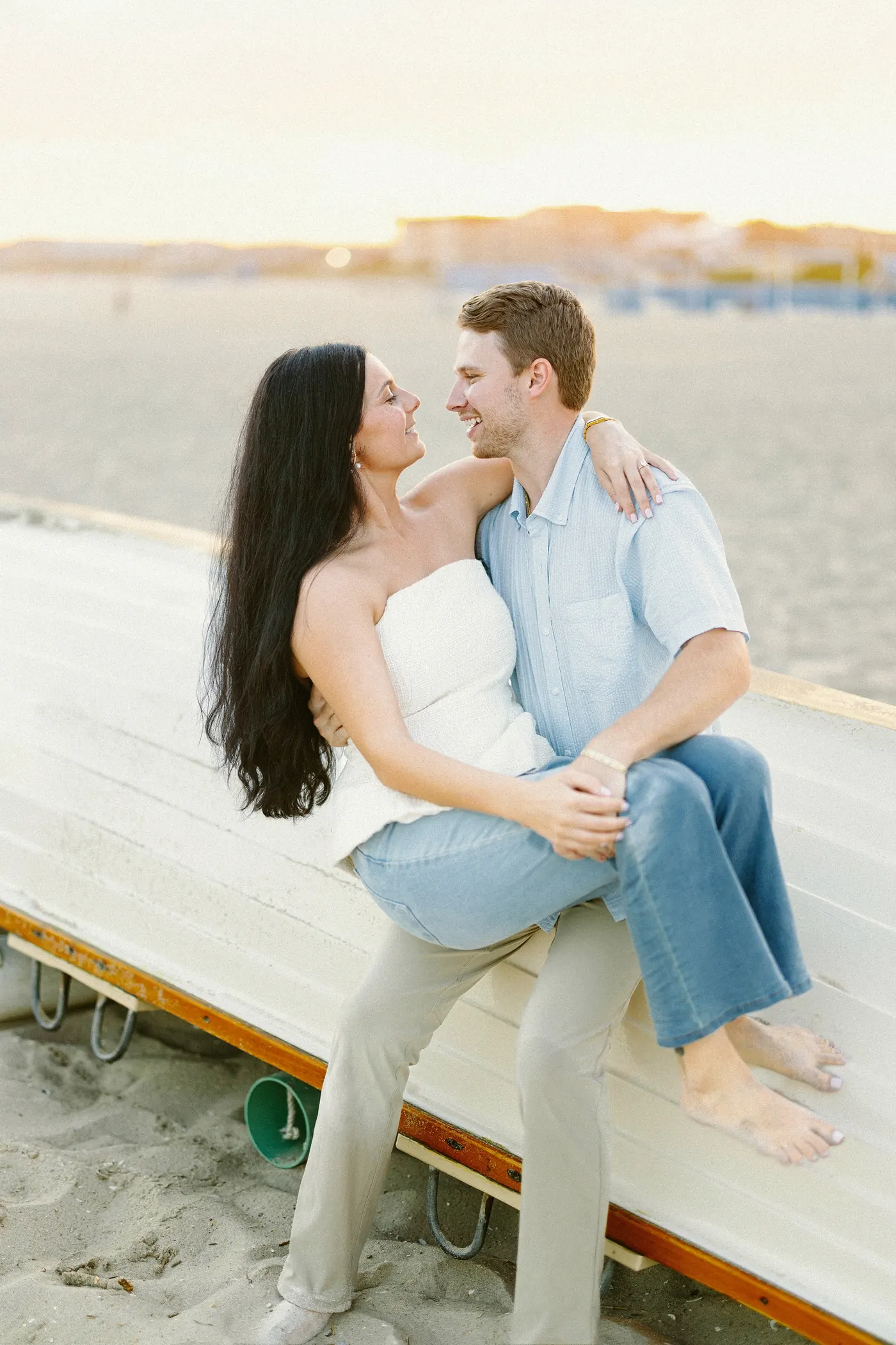 Mason and Morgan sitting together on a boat on the beach