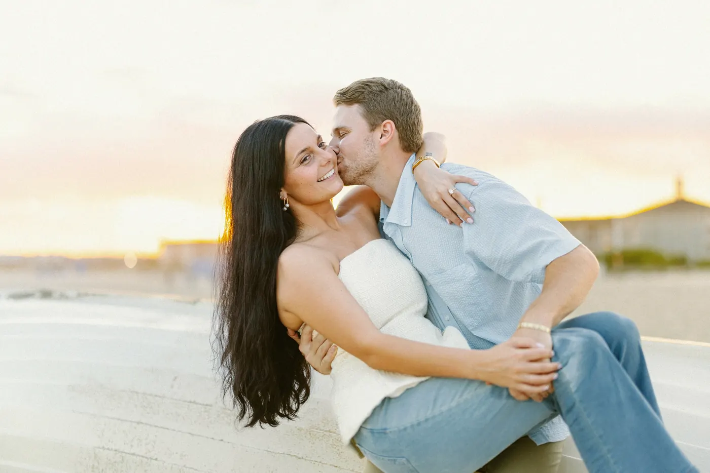Mason and Morgan kissing on the sand at sunset