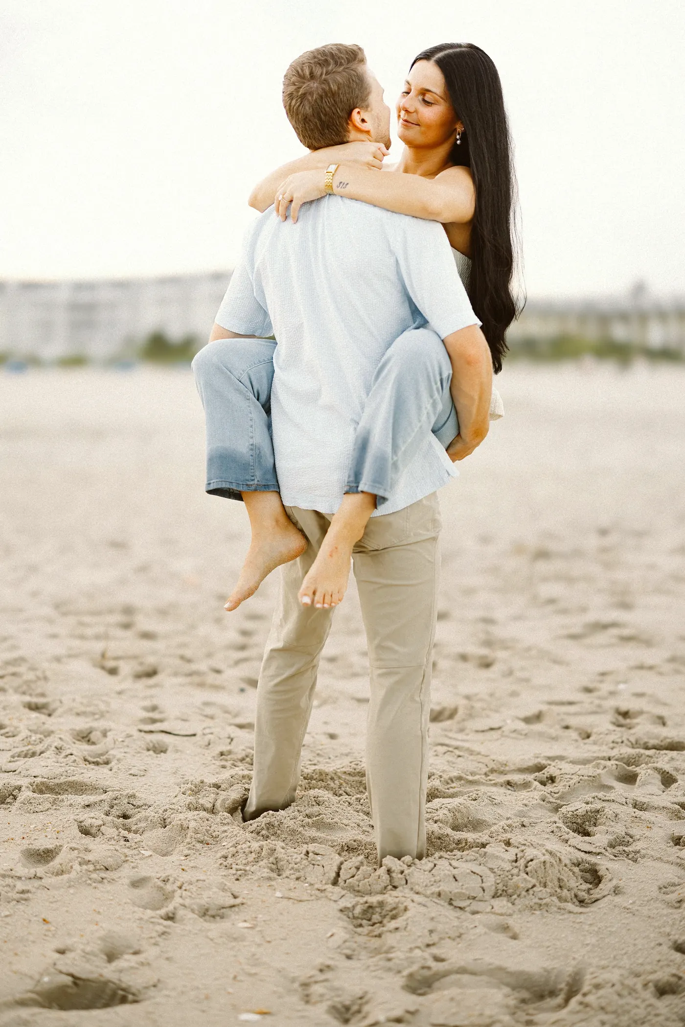 Morgan riding piggyback on Mason on the beach