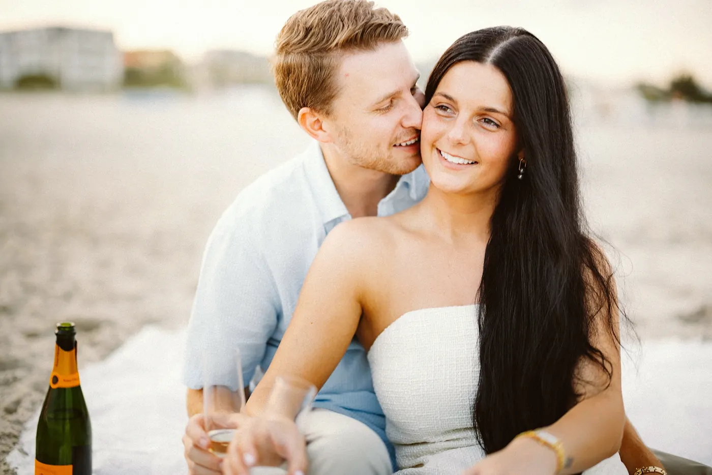 Mason and Morgan cuddled up with champagne on the beach