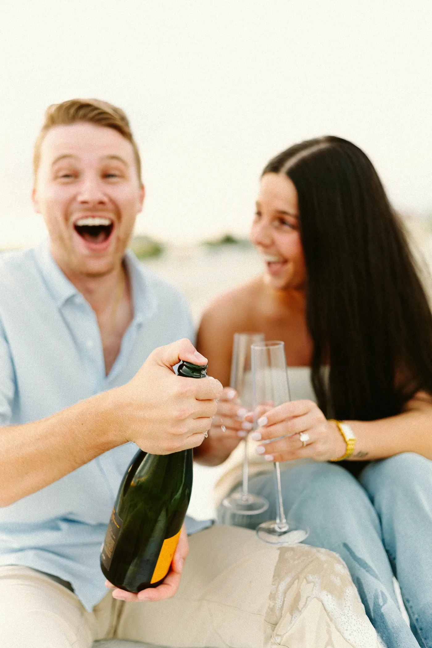 Mason and Morgan laughing as the champagne bubbles over