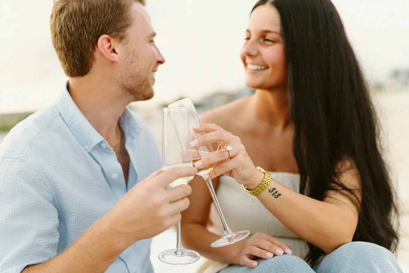 Mason and Morgan toasting with champagne on the beach