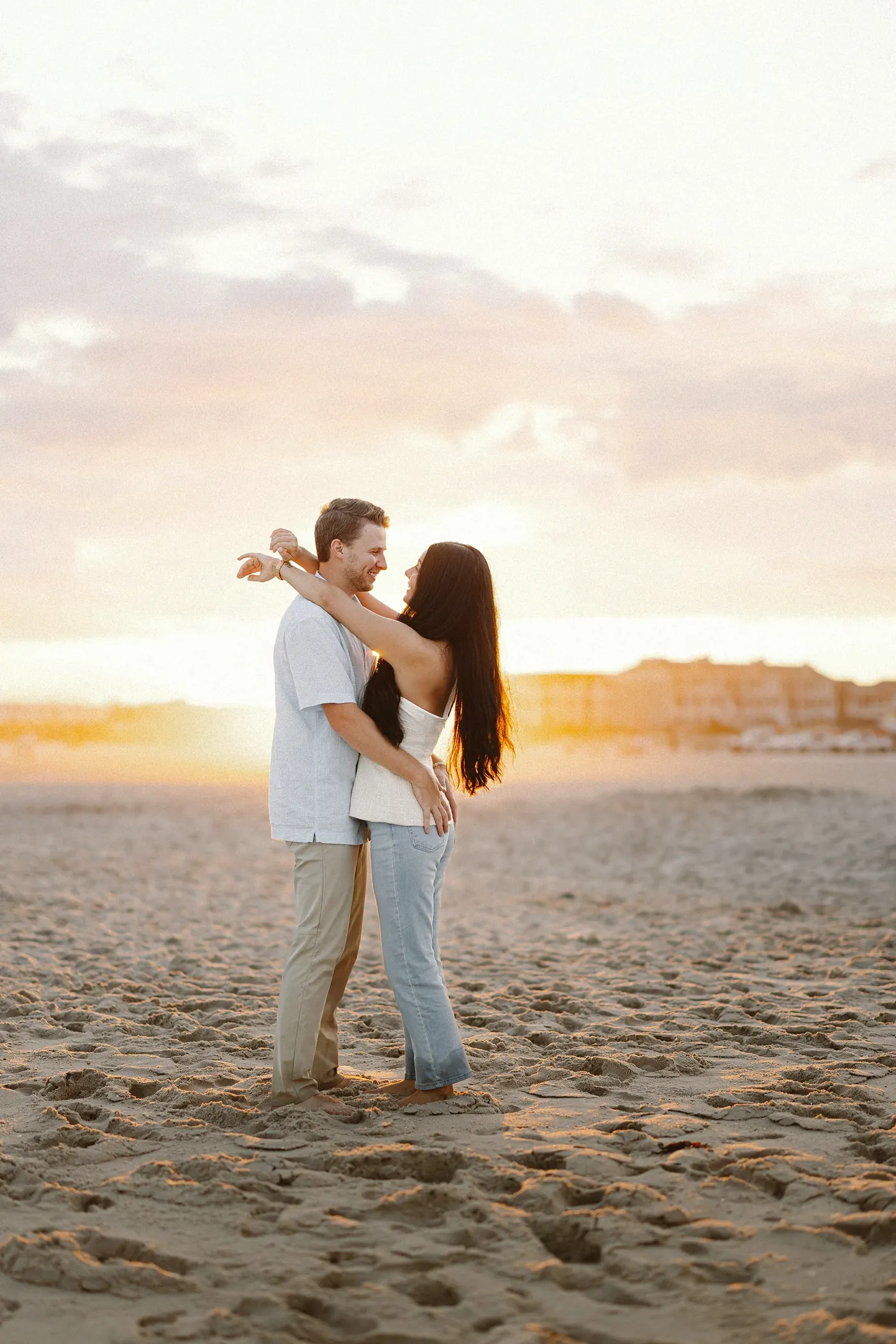 Mason and Morgan embracing on the beach at sunset