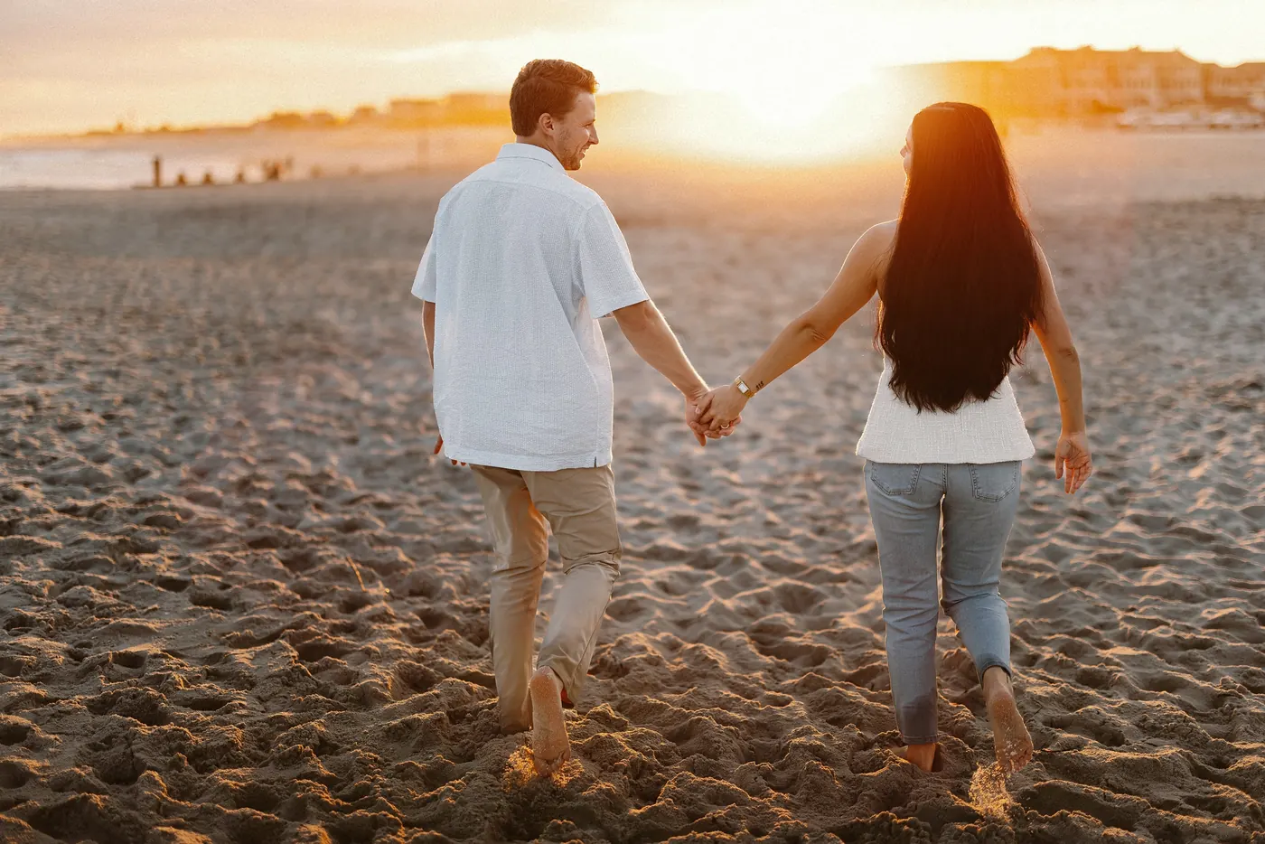 Mason and Morgan walking hand in hand toward the sunset in Cape May, NJ, near Congress Hall
