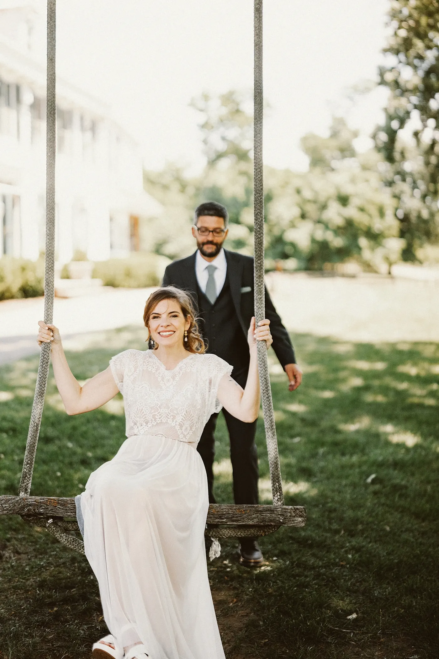 Erica smiling on the rope swing with Matt standing behind her at Johnson's Locust Hall Farm in Jobstown, NJ