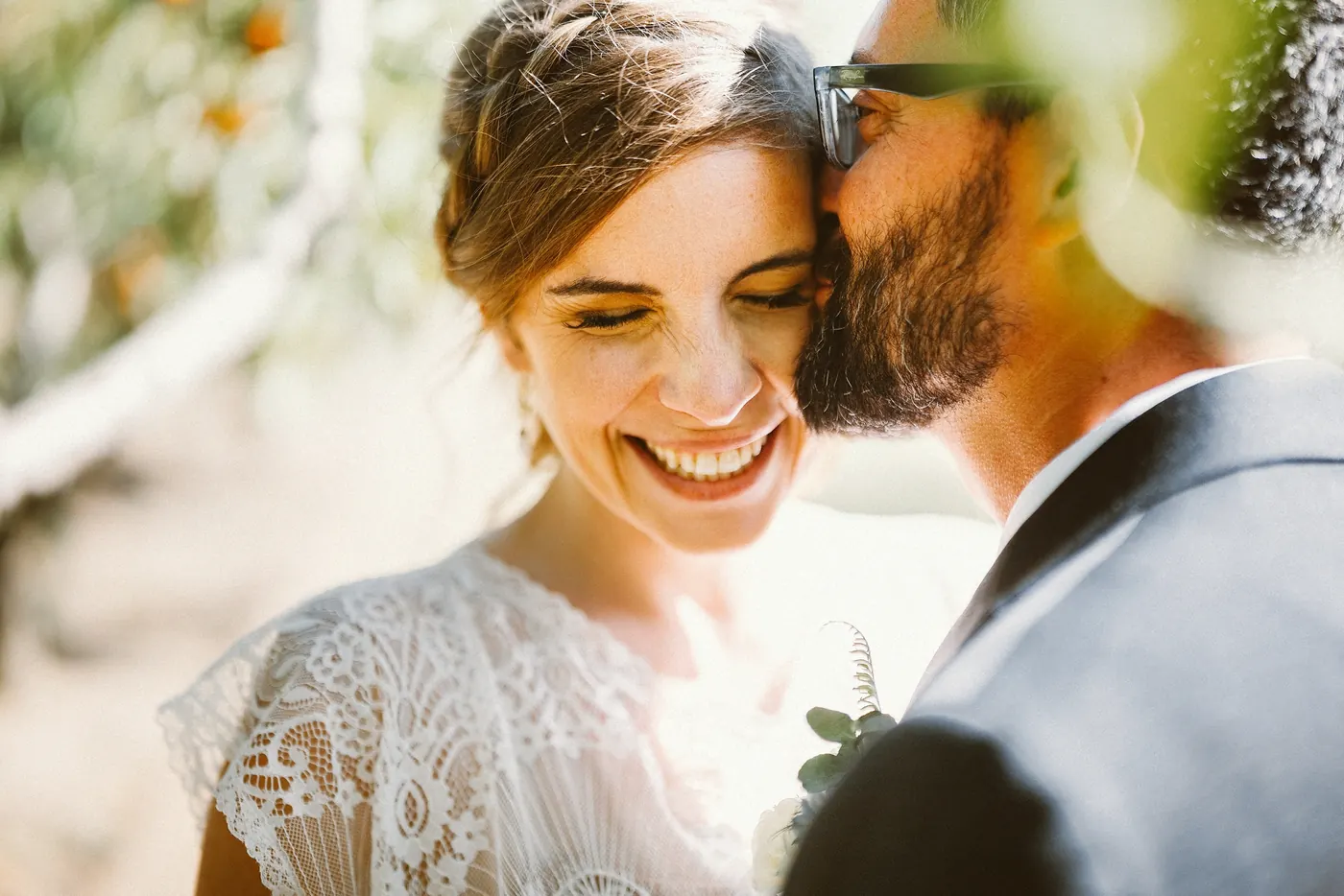 Erica smiling with her eyes closed as Matt leans in close in the orchard at Johnson's Locust Hall Farm in Jobstown, NJ