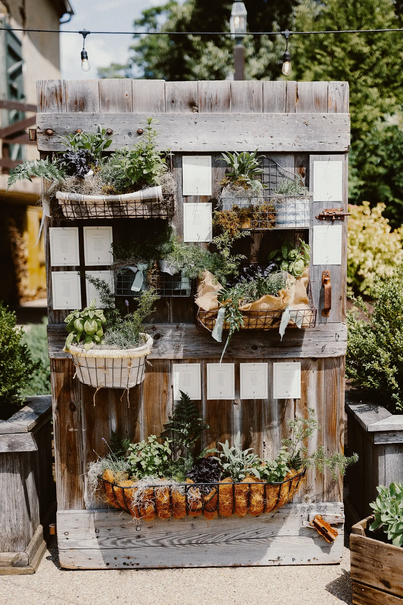 A rustic wooden seating chart decorated with plants at Johnson's Locust Hall Farm in Jobstown, NJ