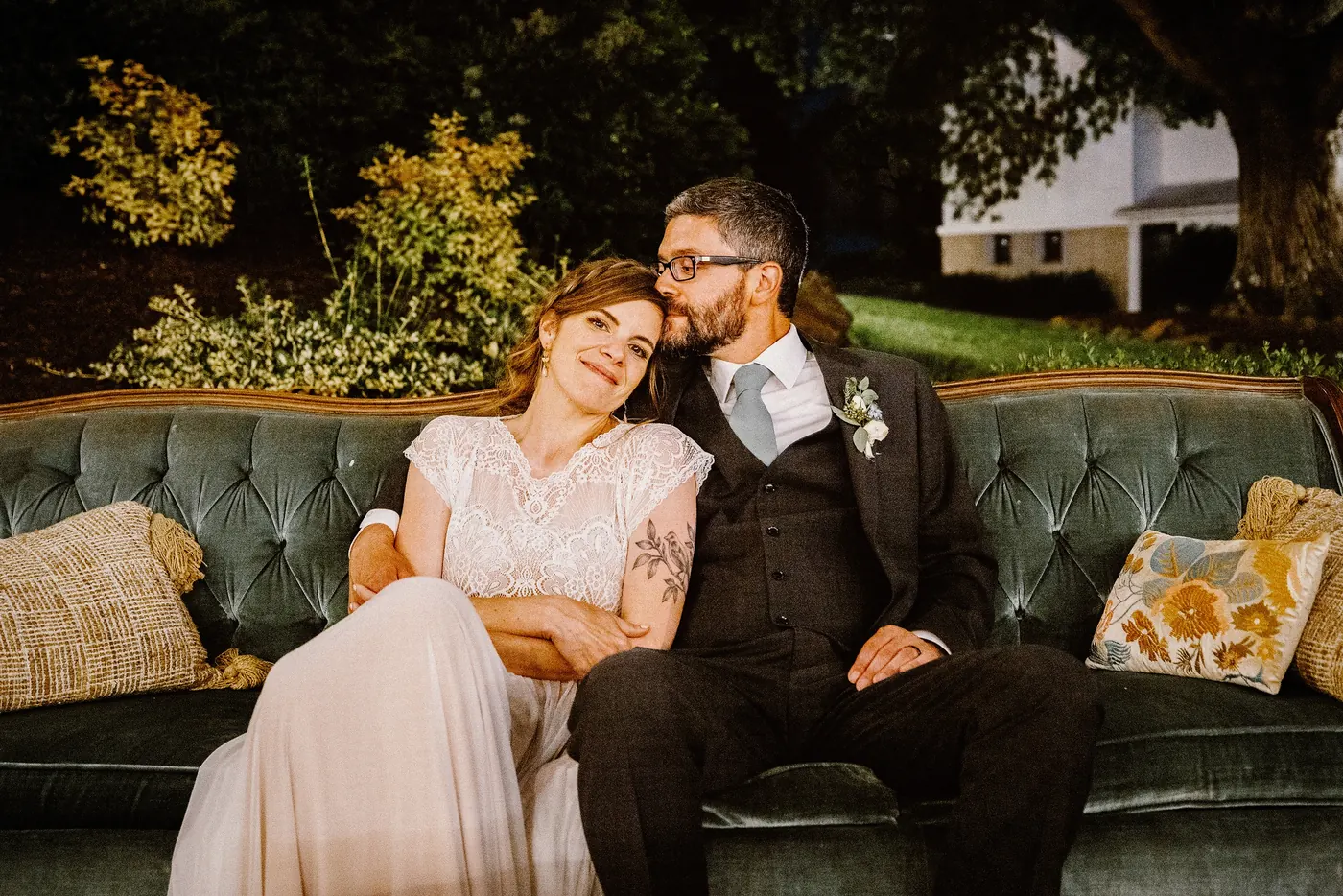 Matt and Erica relaxing on a green velvet sofa outside at Johnson's Locust Hall Farm in Jobstown, NJ