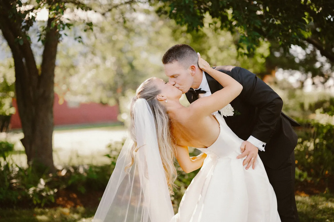 Steve dipping Madison for a kiss with the barn at Bishop Farmstead behind them