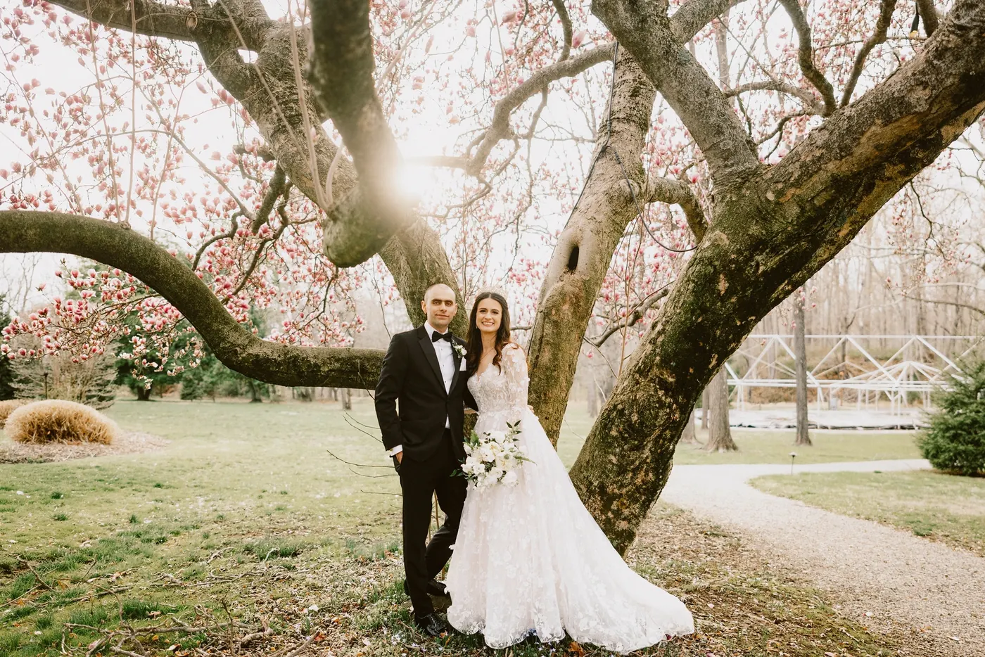 Steve and Maria standing beneath a blooming magnolia tree at The Woolverton Inn in Stockton, NJ