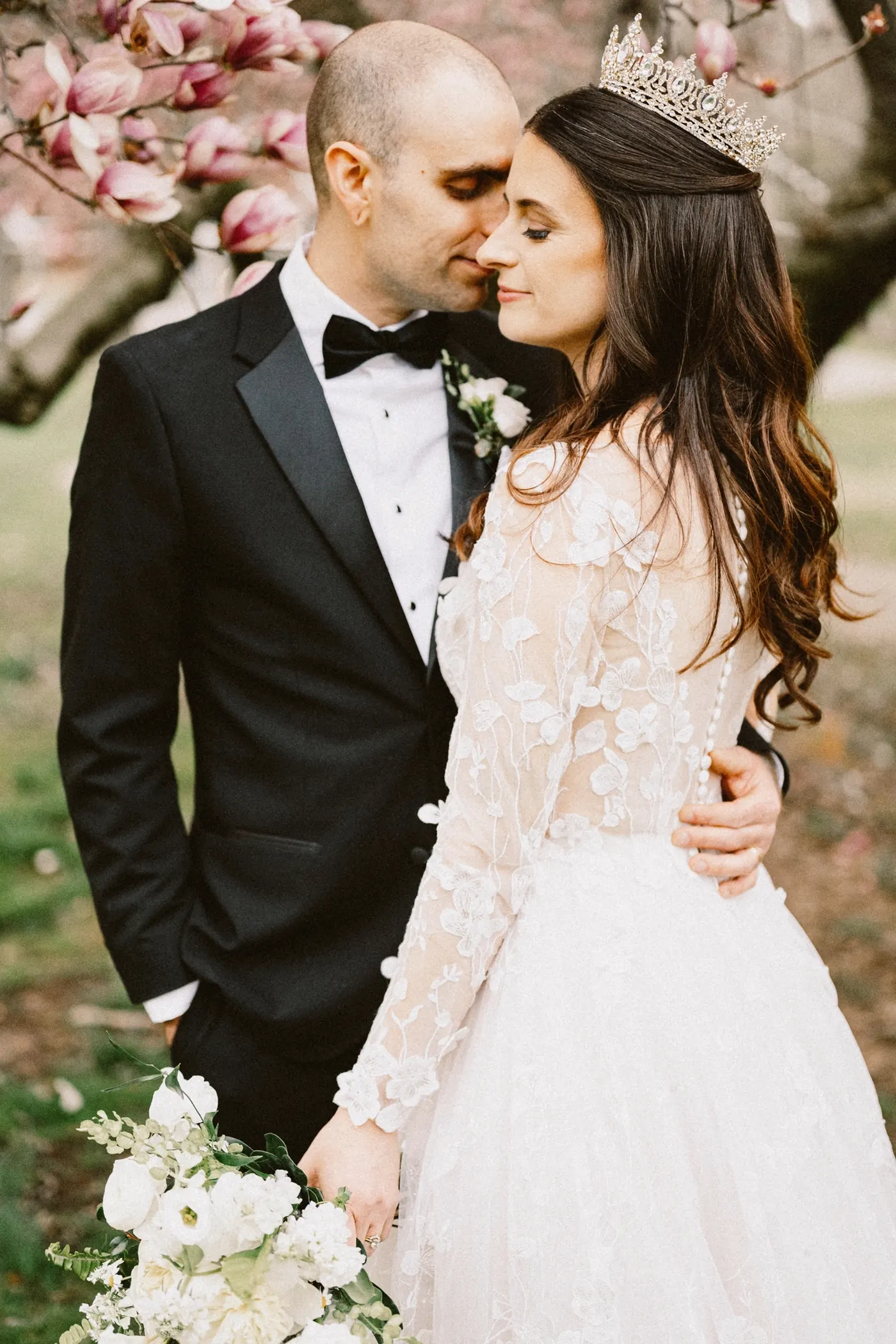 Steve kissing Maria's forehead in front of pink magnolia blossoms