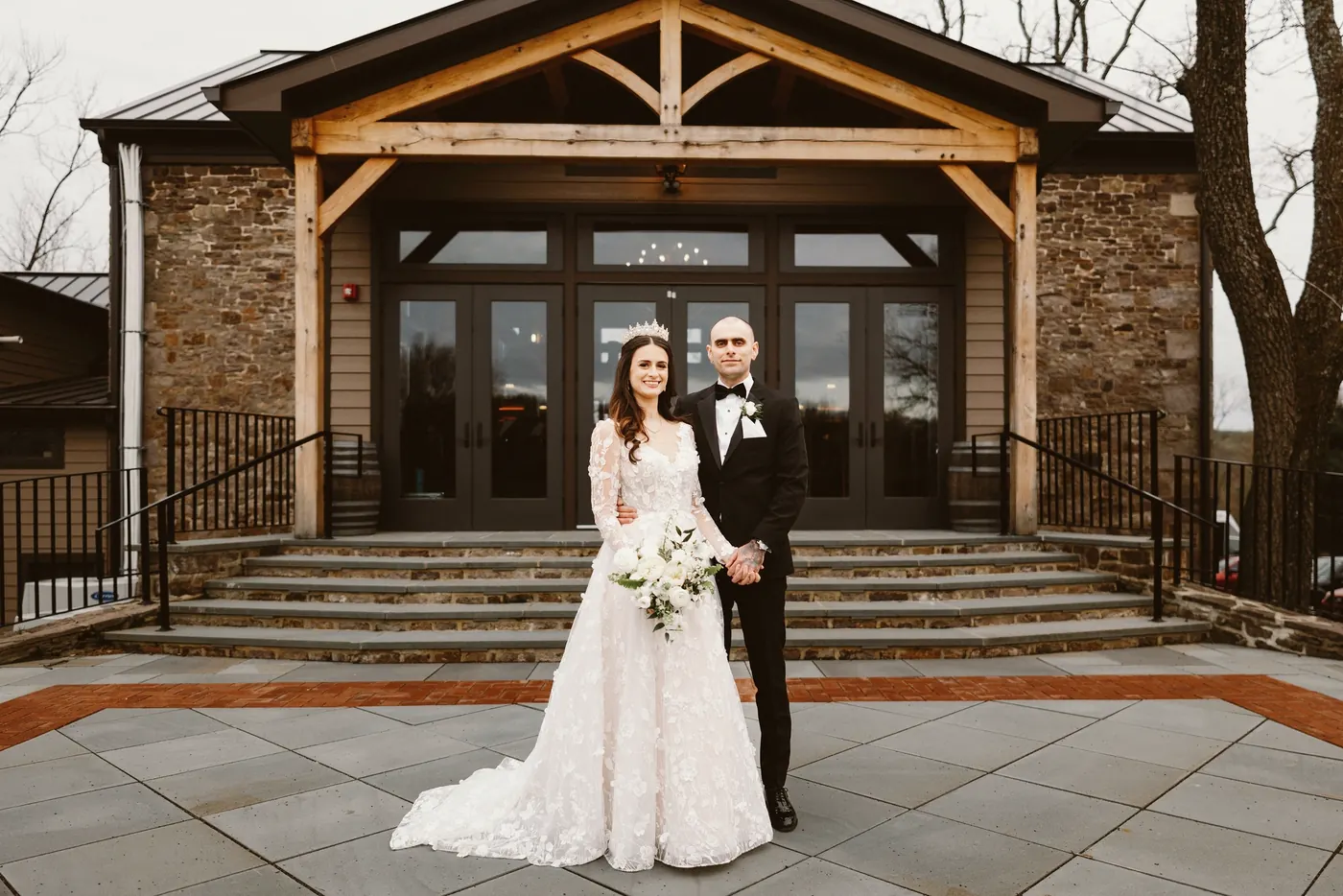 Steve and Maria in front of the stone and timber reception hall at The Woolverton Inn in Stockton, NJ