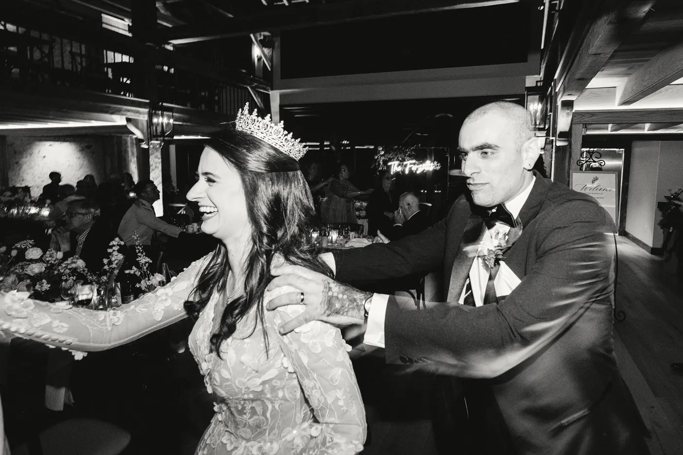 Steve and Maria laughing together on the dance floor, in black and white